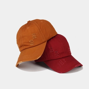 Distressed vintage cotton baseball caps in ginger and burgundy with worn hole details