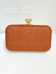 Macro shot of bronze sequin evening clutch featuring gold metal clasp and chain strap
