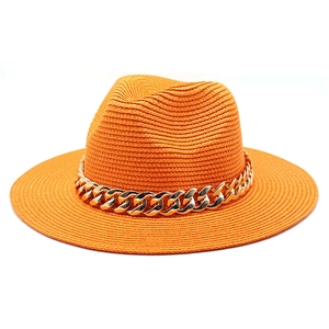 Detailed view of an orange straw jazz hat featuring a decorative thick gold chain band