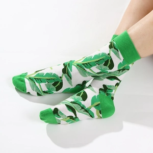White crew socks featuring green tropical leaf patterns with green heel and toe accents