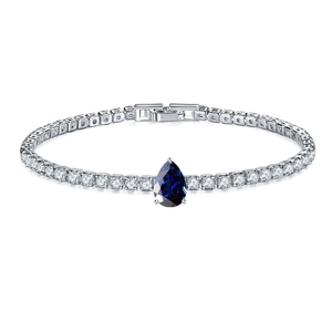Detail of tennis bracelet with white zircons and a pear-cut blue sapphire centerpiece