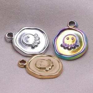Detailed macro view of octopus relief pendants in gold, silver, and rainbow steel