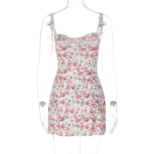 Detalle del estampado floral rosa y el diseño del busto en un vestido blanco de verano
