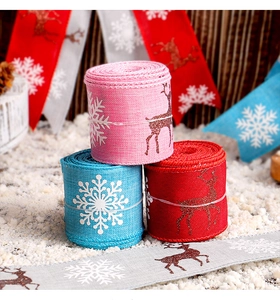 Primer plano de cintas navideñas de arpillera con renos brillantes y copos de nieve