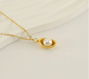 Détail d'une chaîne plaquée or 18k avec une grande perle blanche sertie de métal doré