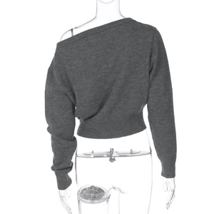 Détail d'un haut en maille gris foncé ajusté avec encolure asymétrique et manches longues