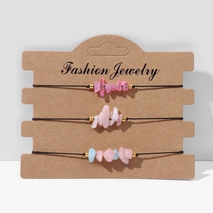Gedetailleerd overzicht van drie handgemaakte armbanden met natuurstenen op kraftpapier