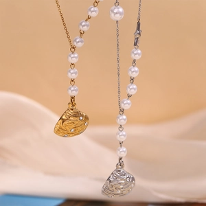 Close-up of gold and silver necklaces featuring pearls and seashell pendants with crystals