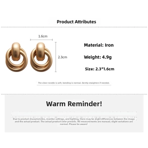 Detailed specs of matte gold geometric hoop earrings made of iron with silver needles