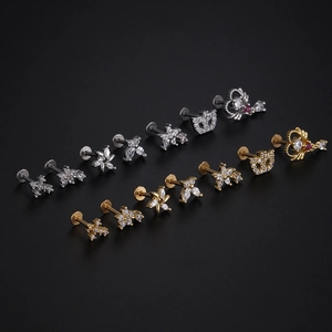 Macro shot of stainless steel labret studs with butterfly and flower crystal motifs