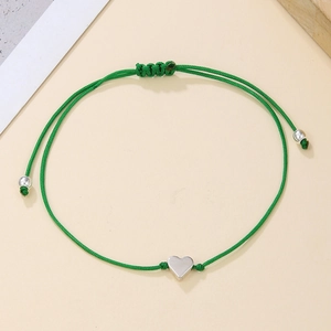 Detail of adjustable green braided cord bracelet with a polished silver heart charm