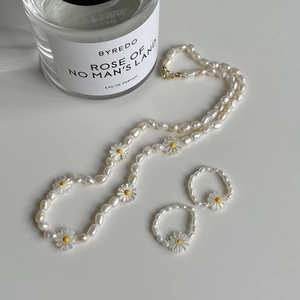 Elegant set with freshwater pearl daisy necklace and two elastic pearl rings on white