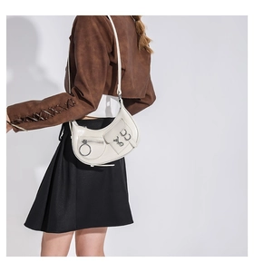 Détail du sac hobo blanc cassé avec décoration en métal et texture en cuir brillant