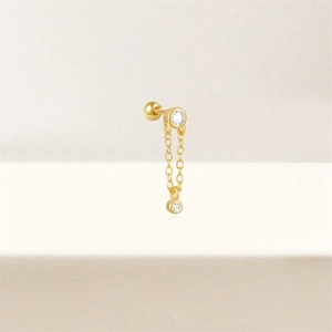 Detail of gold tassel chain earring featuring two sparkling white zircon accents