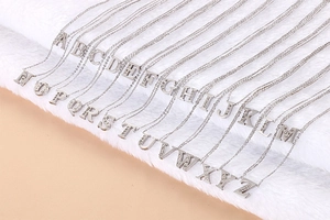 Macro shot of 26 stainless steel alphabet pendant necklaces with sparkling cubic zirconia