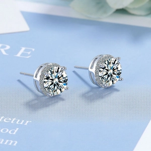 Close-up of 2-carat round-cut cubic zirconia stud earrings with silver pavé halo design
