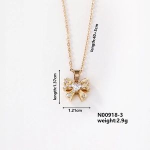 Macro shot of gold bow necklace with heart-shaped zircon and detailed measurements