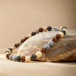 Détail d'un collier de perles bohème aux couleurs mixtes posé sur une pierre naturelle