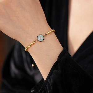 Détail du bracelet œil protecteur avec zircons bleus et cordon doré ajustable