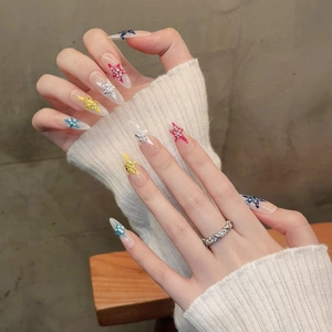 Handgefertigte Stiletto-Kunstnägel mit bunten 3D-Sternen und transparentem Design