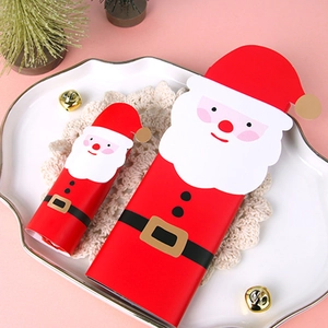 Festive Santa Claus paper gift boxes for Christmas cookies and candy packaging on a plate