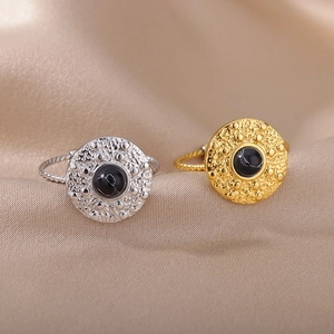 Vintage stainless steel ring with black turquoise on silk background, gold and silver