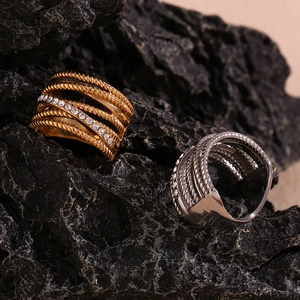 Detail of gold and silver multi-layer twisted rings with crystals on black rock