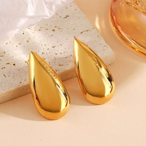 Chic gold teardrop earrings in polished stainless steel on a textured stone base
