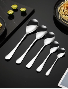 Detailed overhead view of five stainless steel spoons in various sizes for dining use