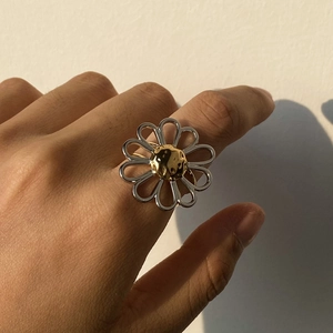 Two-tone hollow daisy flower open ring in 18K gold and stainless steel on finger