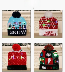 Detail view of four LED knitted Christmas hats with snowman and reindeer patterns