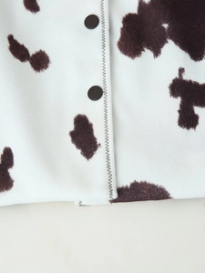 Macro shot of cow print jacket featuring black buttons and detailed stitching texture