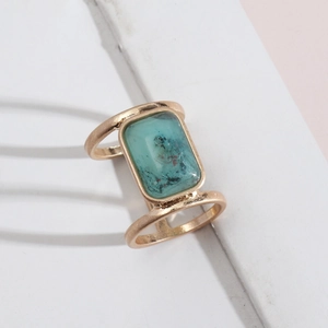 Modern gold ring featuring a rectangular turquoise stone with unique natural textures