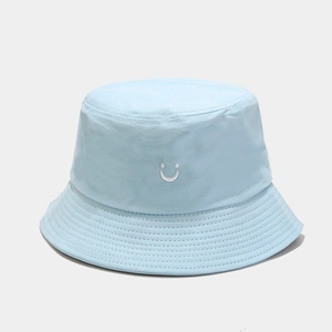 Close-up of light blue cotton bucket hat featuring smiley face embroidery and twill fabric