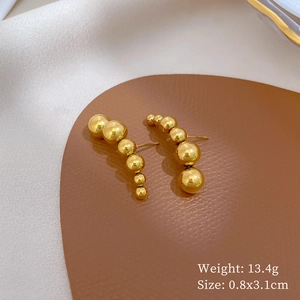 Detail view of gold beaded titanium earrings on leather mat with weight and size specs