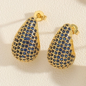 Detailed macro view of gold-plated teardrop earrings pavé set with blue zircon stones