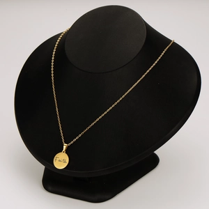 Golden stainless steel necklace with round Faith engraved pendant on black display stand