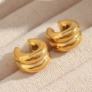 Macro shot of 18K gold plated double-layer C-shape ear cuffs on textured fabric