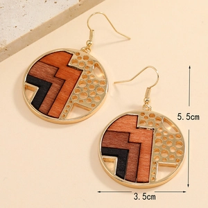 Vue détaillée des boucles d'oreilles en bois et alliage doré avec dimensions de 5,5x3,5 cm