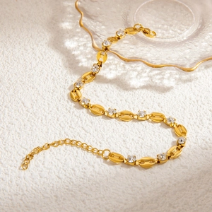 Detail of gold coffee bean link bracelet with clear cubic zirconia stones and lobster clasp