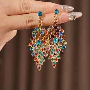 Close-up of vintage gold leaf earrings with colorful rhinestones in a luxury jewelry set