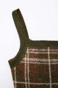 Close-up detail of dark green and beige plaid knit vest showing wool blend texture
