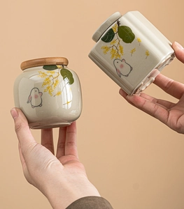 Detailed view of ceramic tea canisters featuring hand-painted rabbit and floral patterns