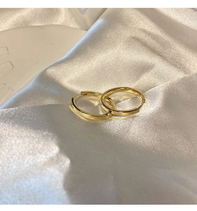 Orecchini a cerchio dorati in stile francese minimalista su elegante tessuto di seta