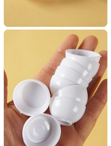 Miniature white plastic cups shown in hand for scale on bright yellow background