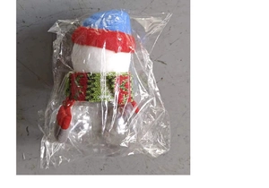 Detail of Christmas snowman candy jar with colorful knit hat and scarf in packaging