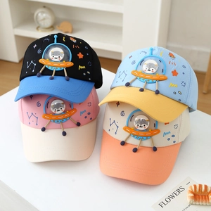 Detailed view of colorful kids baseball caps with 3D cartoon spaceship designs.