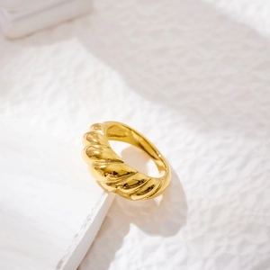 Macro shot of gold croissant ring featuring 3D spiral texture and polished metal finish