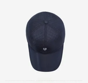 Close-up of dark blue quilted baseball cap with silver metal R logo and stitching details