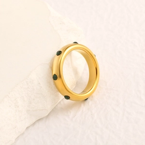 Détail de la bague plaquée or 18 carats avec strass vert émeraude sur fond pierre